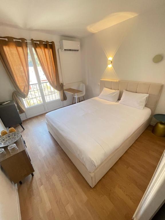 a bedroom with a large white bed and two windows at Aparthotel New Palmarium in Amélie-les-Bains-Palalda