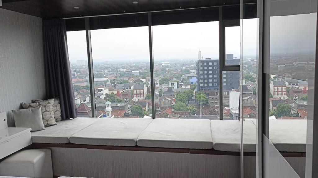 a room with a large window with a white mattress at Ruby Apartment #34 in Yogyakarta