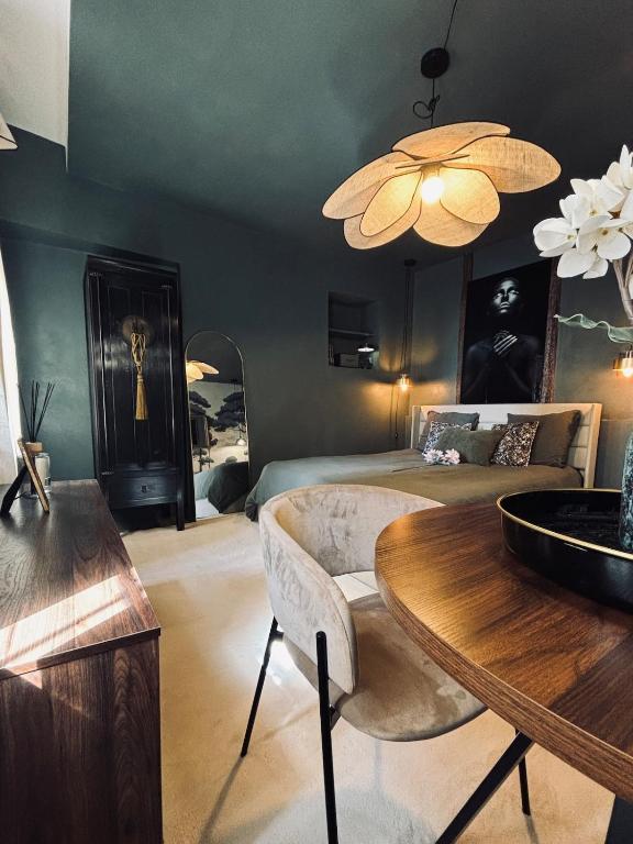 a bedroom with a bed and a table and a dining room at La Suite Archevêché by Collection Signature - Hypercentre Albi - Parking inclus in Albi
