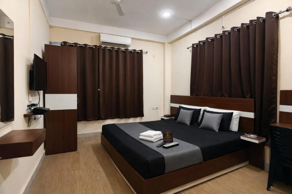 a bedroom with a bed and a television in it at Whitestone Inn in Guwahati