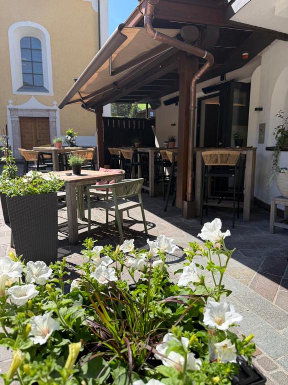 a patio with a table and chairs and flowers at Hotel Mesnerwirt - Zentrumslage in Westendorf