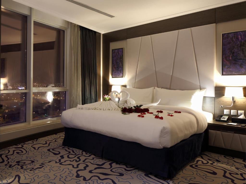 a bedroom with a large bed with flowers on it at Swiss Flora Royal Hotel Riyadh in Riyadh