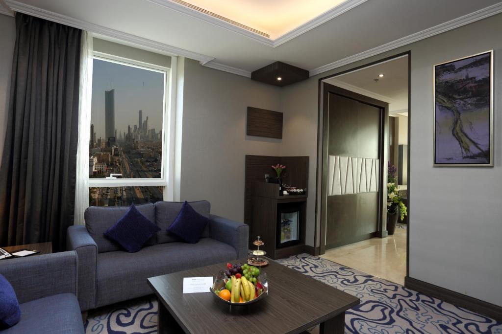 a living room with a couch and a table at Swiss Flora Royal Hotel Riyadh in Riyadh