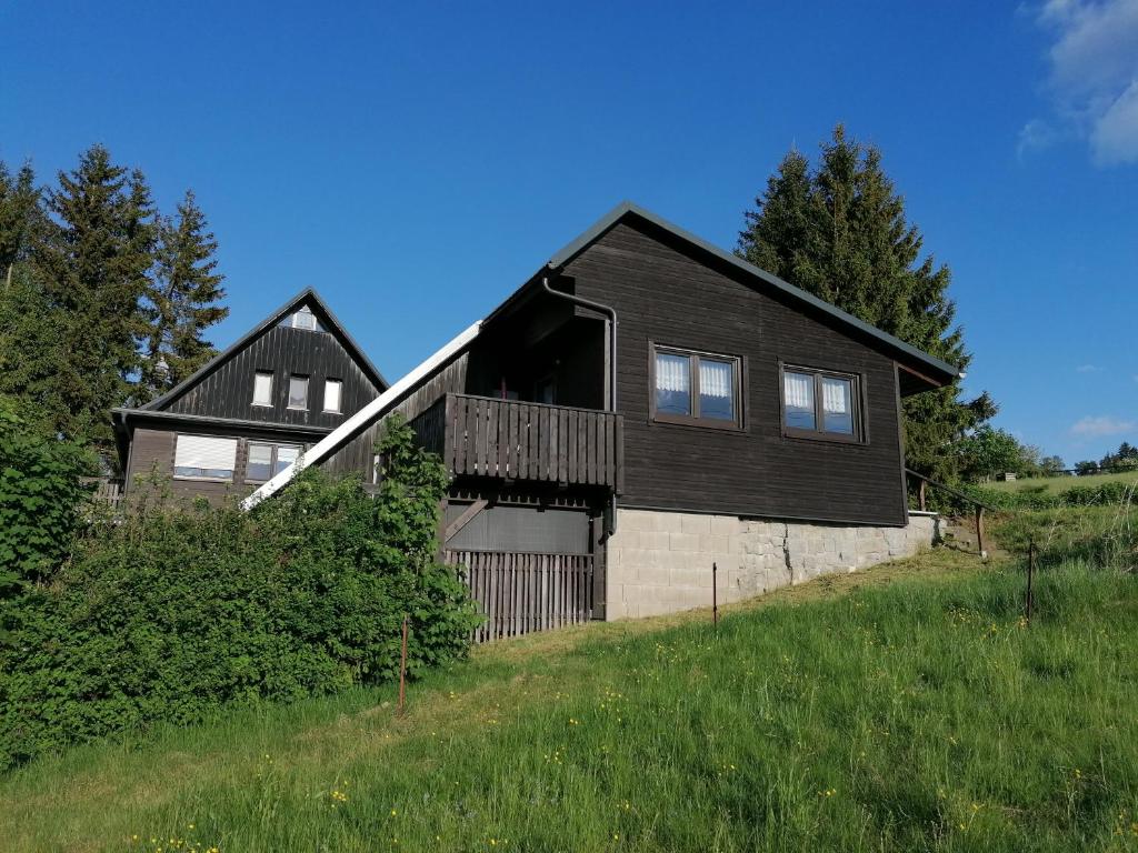 a black house on the side of a hill at Ferienhaus Lisa in Klingenthal