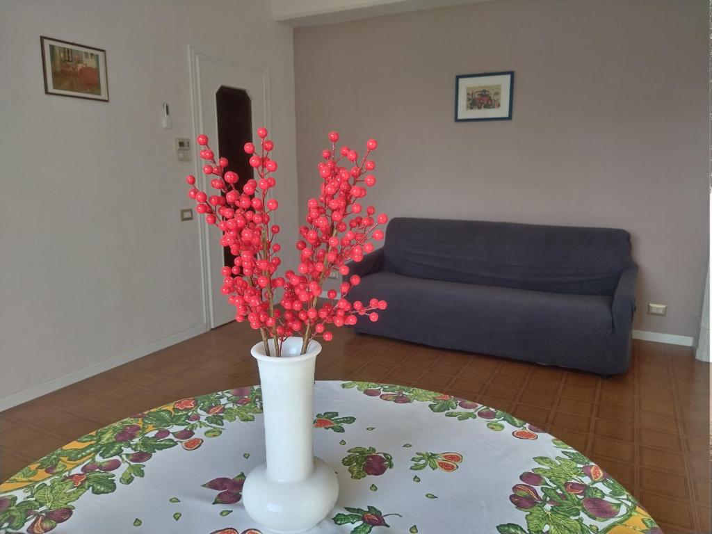 a vase with red flowers on a table in a living room at Scer GEA in Cerro Maggiore
