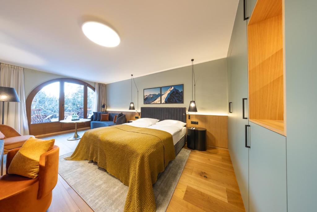 a bedroom with a bed and a living room at Hotel Rosatsch Residence in Pontresina