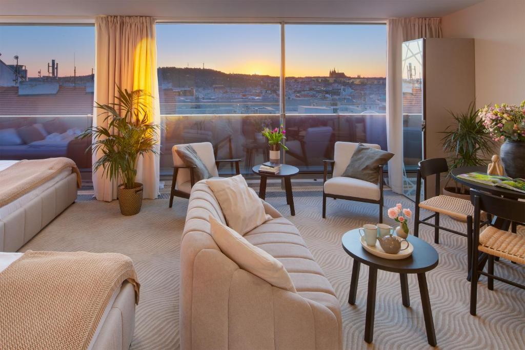 a living room with a couch and a large window at Wenceslas Hotel & Apartments in Prague