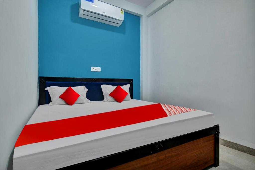 a bedroom with a bed with red and blue walls at Hotel O My Choice in Indore