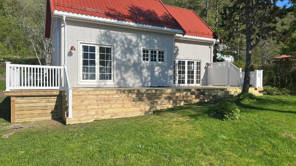 a small white house with a red roof at Sigerfjordveien 501 in Sortland