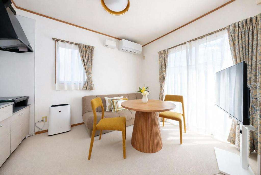 a small living room with a table and chairs at Beppu Paw House in Beppu