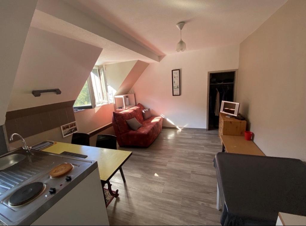 a living room with a couch and a table at L Escale du Lioran in Le Lioran