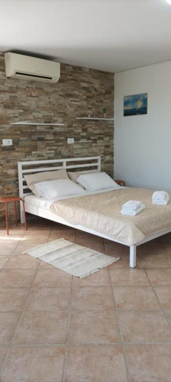 two beds in a room with a brick wall at Room Monika in Izola