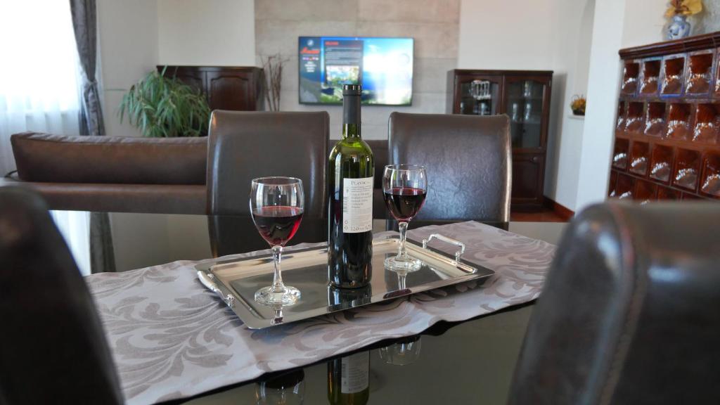 a bottle of wine and two glasses on a table at Apartments Romana in Postira