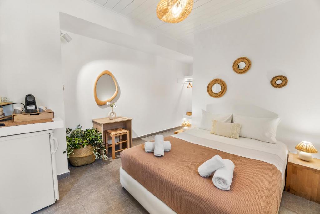 a bedroom with a large bed with towels on it at LausAndros Suites in Andros