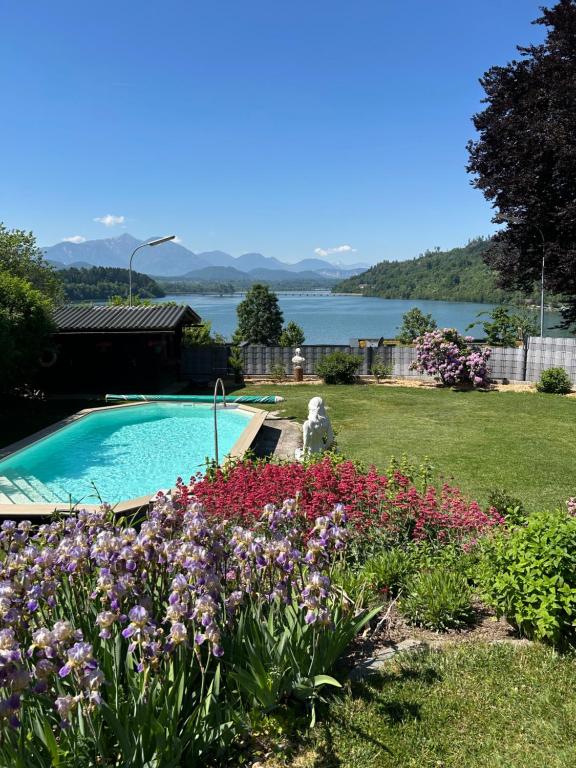 a garden with a swimming pool and flowers at Golden Rooms Exklusiv in Völkermarkt