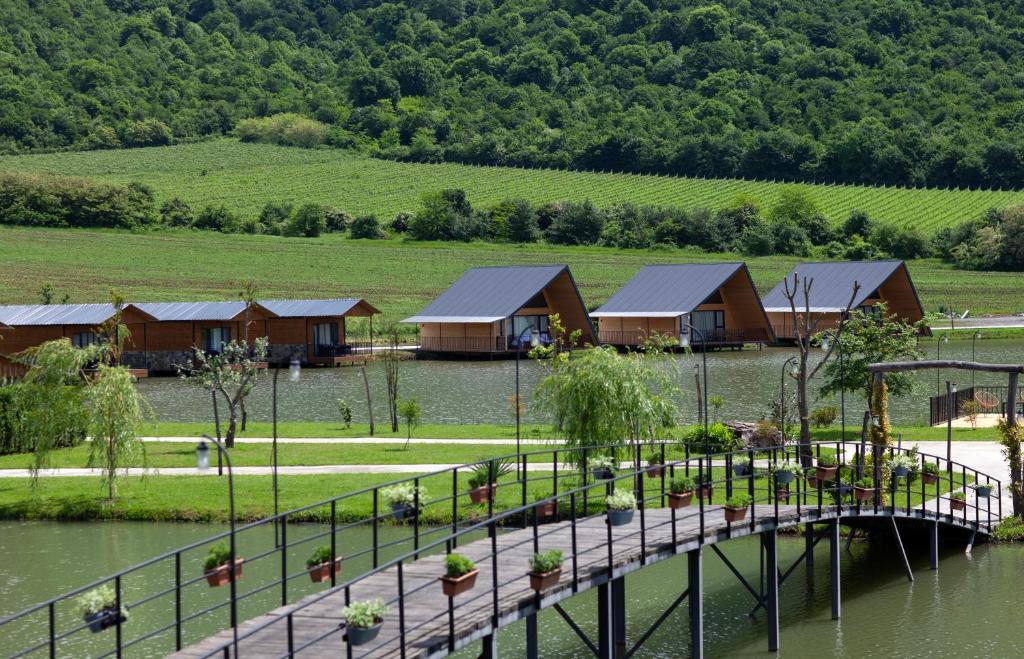 a bridge over a lake with a group of houses at Moretoni Lake Resort in Napareuli