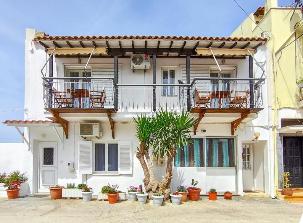 a white building with potted plants in front of it at Al Mar in Skiathos