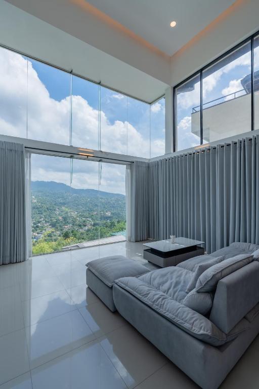 a bedroom with a large bed and large windows at Boutique Dinu in Kandy