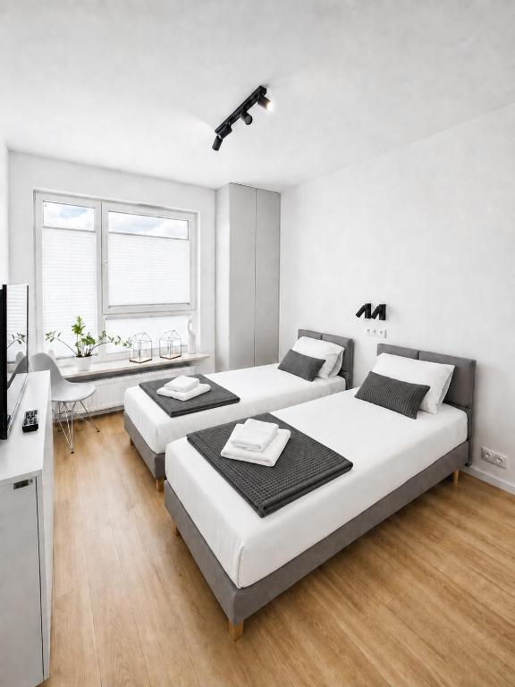 a bedroom with two beds and a desk and a television at APARTAMENT 4 bed 2 room WARSAW in Warsaw