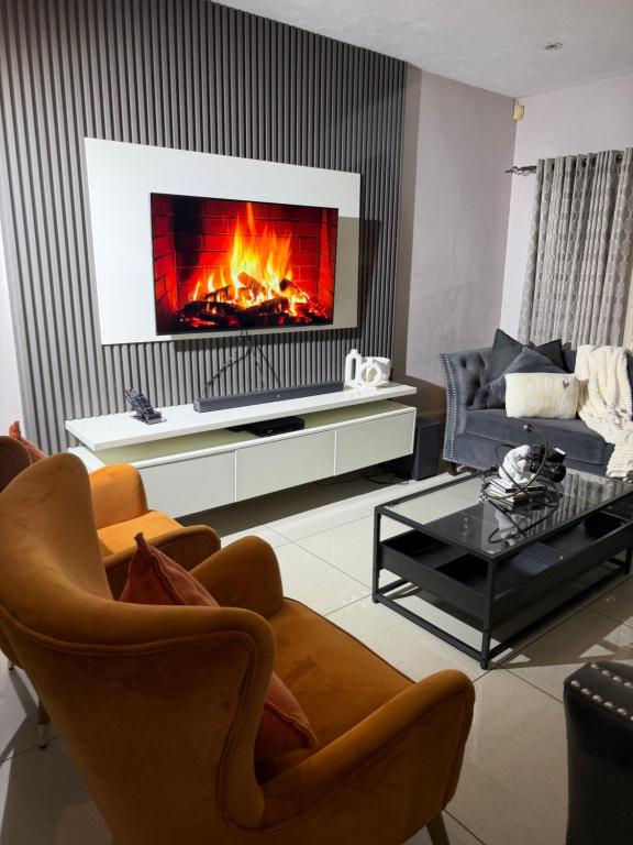 a living room with a couch and a fireplace at Riverside 1 bedroom house for Two in Nelspruit