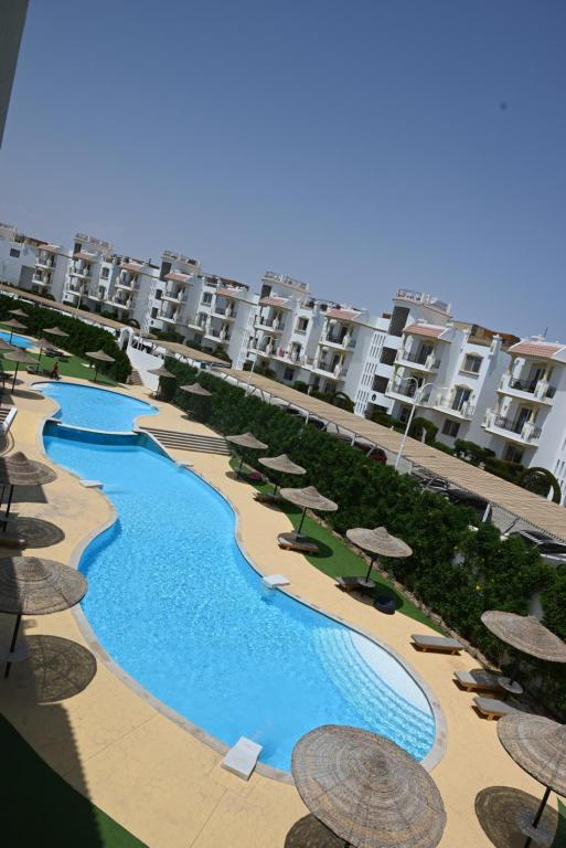 a view of a pool with umbrellas and some buildings at Sharm Hills Azure Suite Topview in Sharm El Sheikh