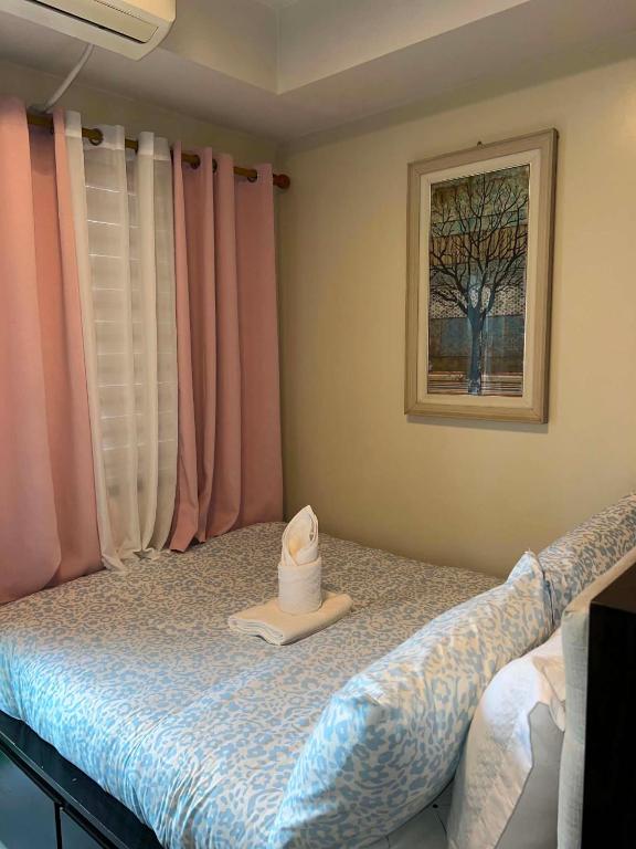 a bedroom with a bed with a hat on it at Shell Residences in Sampong