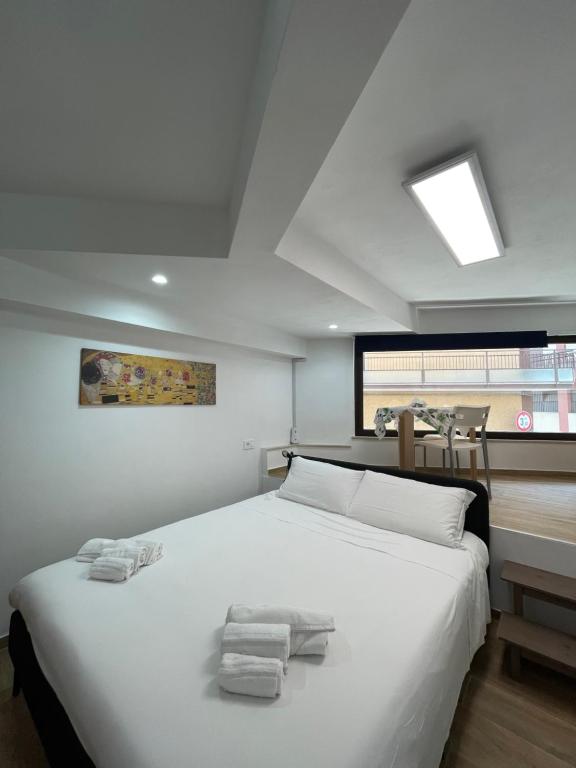a bedroom with a large white bed with towels on it at Casa XX Settembre Deluxe in Misterbianco