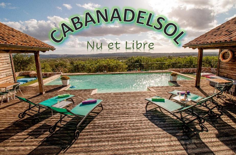 a swimming pool with two chairs and a table at Chambres d'hôtes Naturistes (Nudiste) "Cabanadelsol" - Adults Only in Monte da Charneca