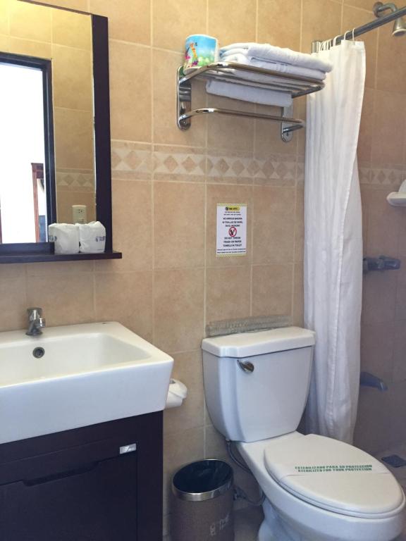 ein Badezimmer mit einem weißen WC und einem Waschbecken in der Unterkunft Park Hotel in Puerto Limón