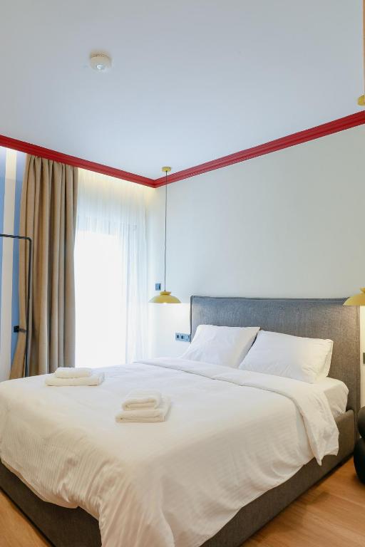 a large white bed with two towels on top of it at Olympia 3 in Xanthi