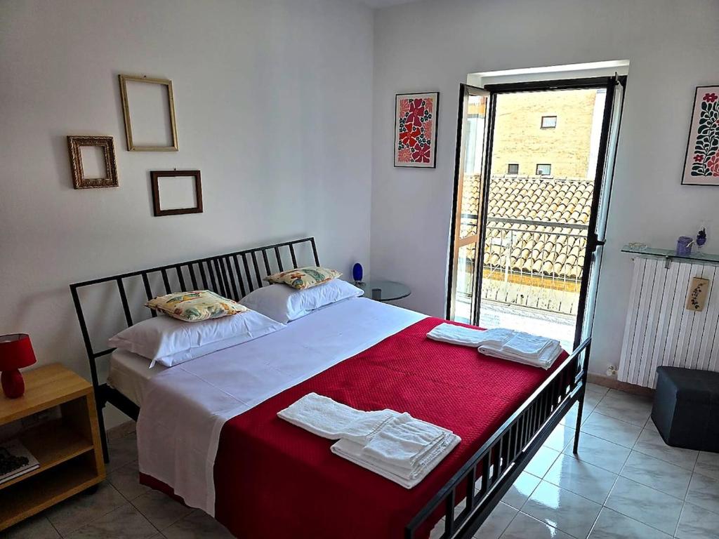 a bedroom with a large bed with a red blanket at Casa Cordara Apartment in Nizza Monferrato