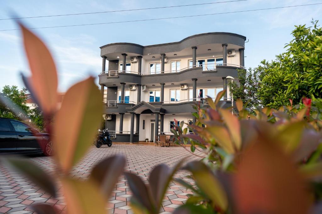 a building with a plant in front of it at Rexha Apartments in Ulcinj