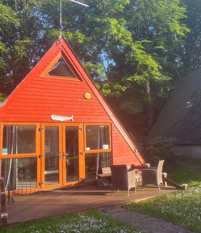 a cabin with an orange roof with a table and chairs at Pebbles Seaside Lodge in Kent