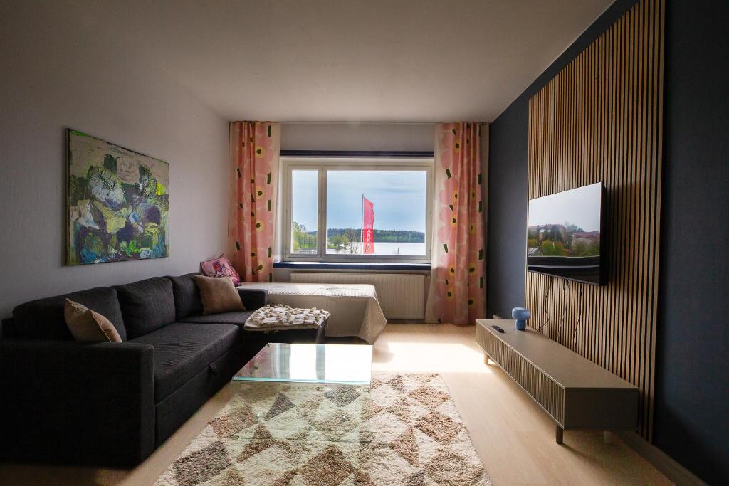 a living room with a couch and a window at Saimaa Design, lake view, AC, Wifi in Savonlinna