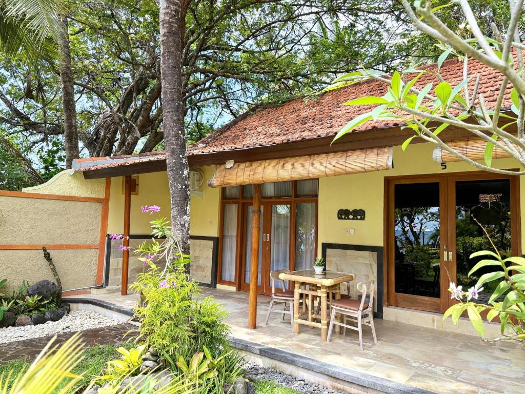 a house with a table and chairs in front of it at Alam Mimpi Bali in Tejakula