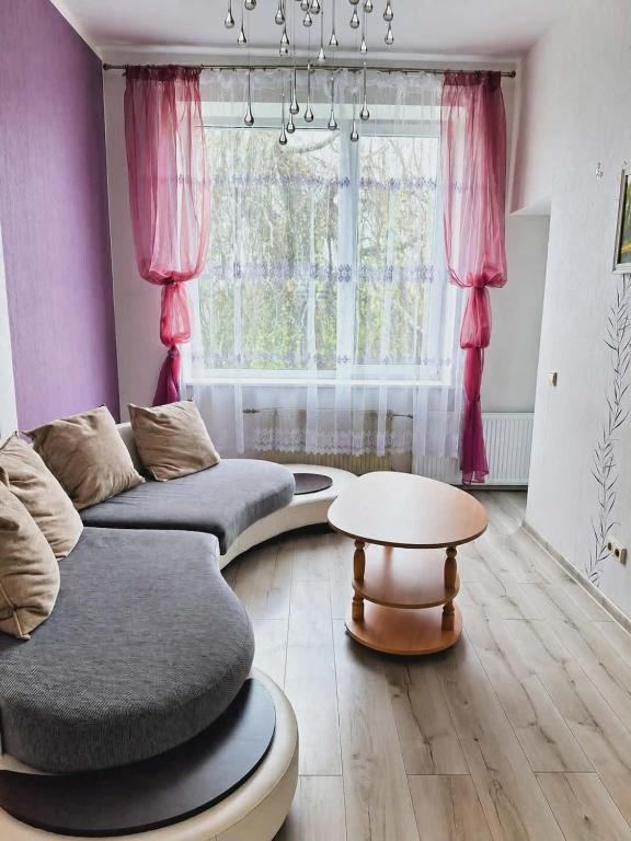 a living room with a couch and a table at Svečių namai miestelio centre in Mosėdis