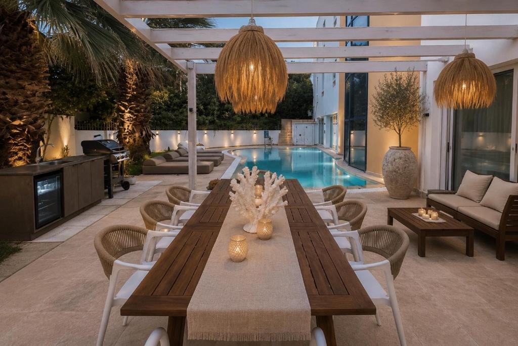 a patio with a table and chairs and a pool at Themis Luxury Private Villa Rhodes with Private Pool in Ialysos