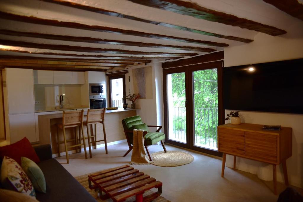 a living room with a couch and a tv and a kitchen at Casas del río in Mira