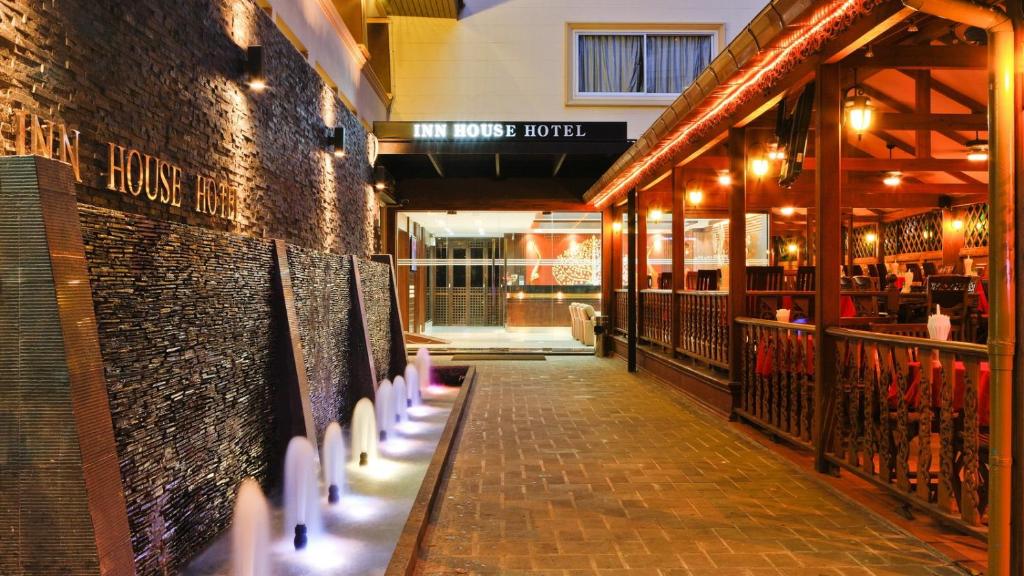 a brick building with a walkway in front of a store at Inn House- SHA Extra Plus in Pattaya