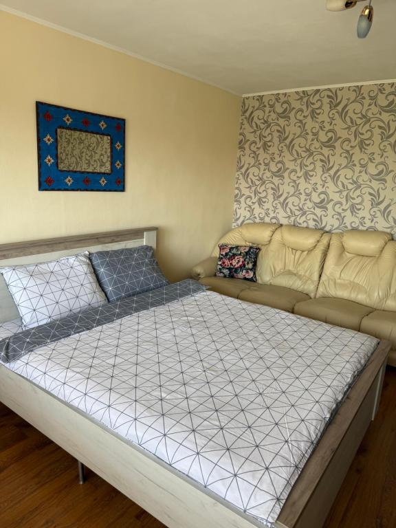 a bedroom with a bed and a couch at Apartament Otopeni#Aeroport#Therme#Natatie in Otopeni