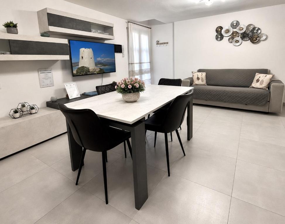 a living room with a table and chairs and a couch at APPARTAMENTO PICASSO in Villasimius