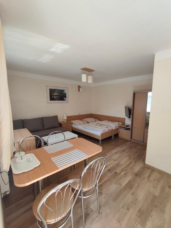 a living room with a table and chairs and a couch at Noclegi Pod Lipami in Zwierzyniec