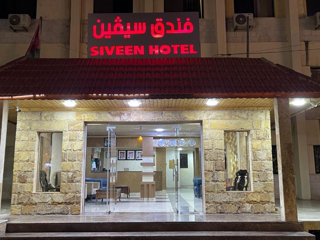 a hotel with a sign on top of a building at Siveen Hotel in Amman