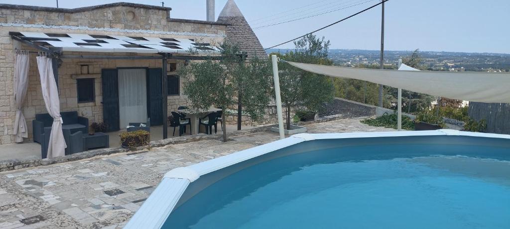 a swimming pool in front of a house at Trullo Monticello in Martina Franca