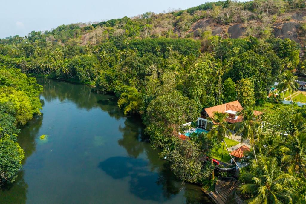 an aerial view of a river with trees and a house at K Manor in Vāzhākulam