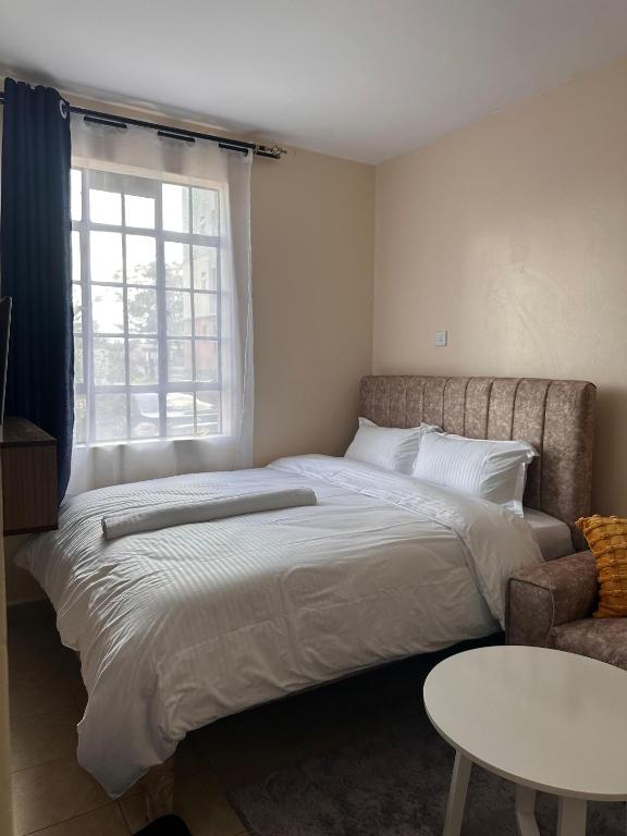 a bedroom with a large bed and a window at Cool Studios, Machakos in Machakos