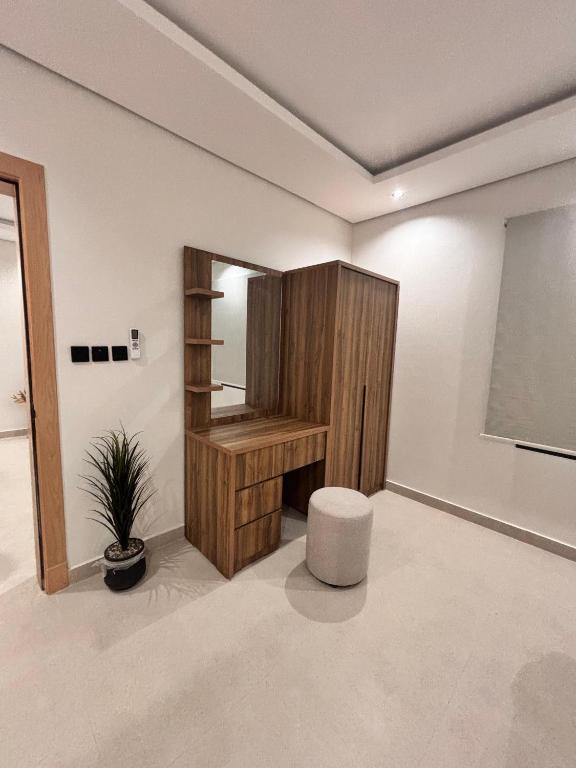 a room with a wooden cabinet and a potted plant at شقق حديثة موثثة in Dammam