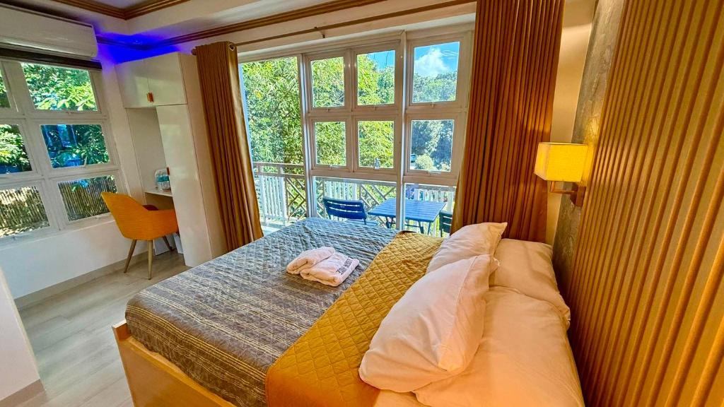 a bedroom with a bed and a large window at S&L Lodging House and Tampisaw Restaurant in Pandan