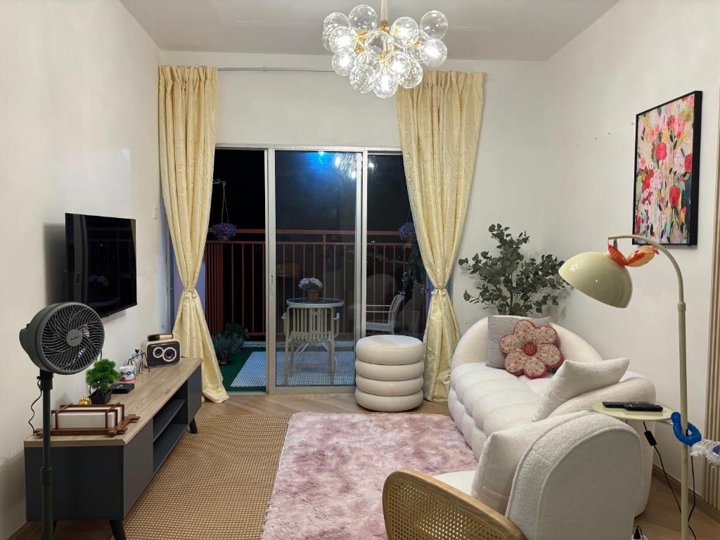 a living room with a white couch and a chandelier at Yunis Cottage Tranquil mountain views Centrum Cameron Highlands in Brinchang