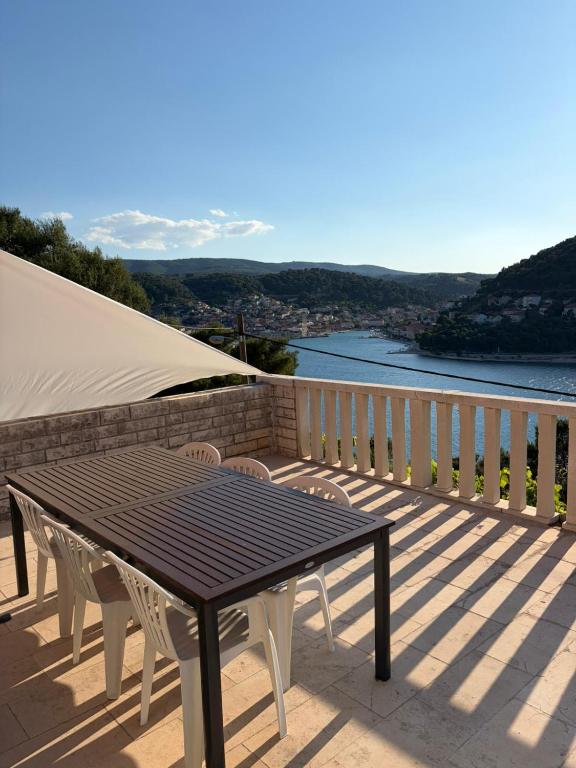 a table and chairs on a balcony with a view of the water at Nice postion, belle vue in Pučišća